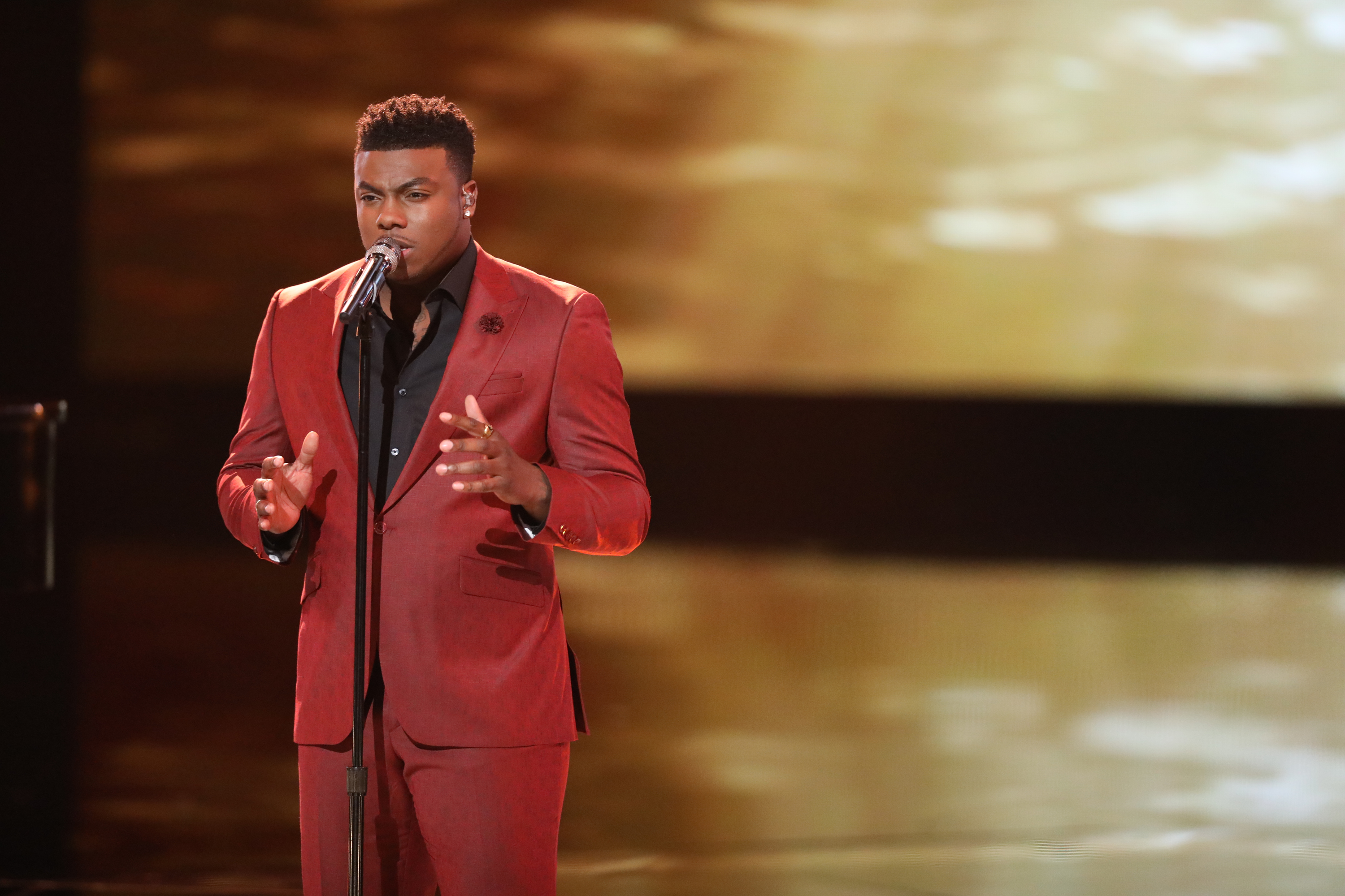 Kirk Jay performing in a red suit on stage