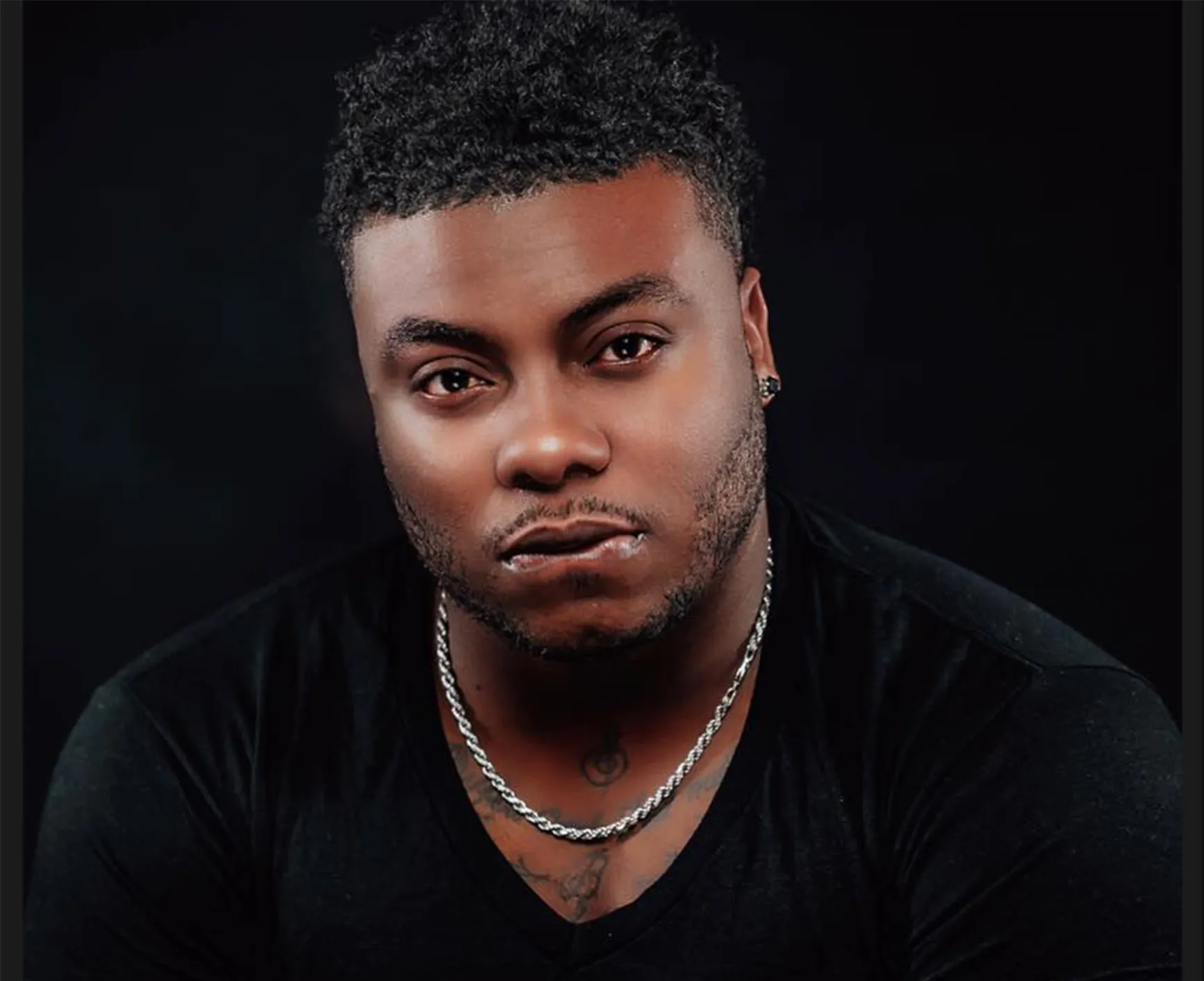 Kirk Jay singing at the piano in a green plaid blazer